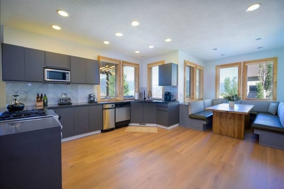 The gourmet kitchen features aplenty of counter space and is equipped with stainless steel appliances, including a microwave, gas stove, and spacious refrigerator.