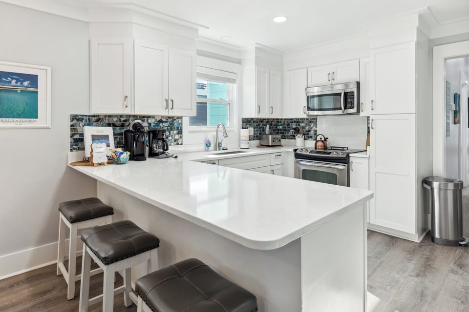 Huge kitchen with a breakfast bar, dining table, and an island w extra seating.