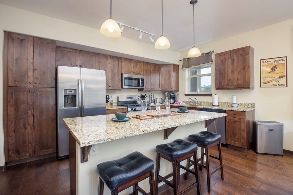 Your fully-equipped kitchen features warm wood cabinetry, granite countertops, and modern stainless appliances for effortless meal preparation.