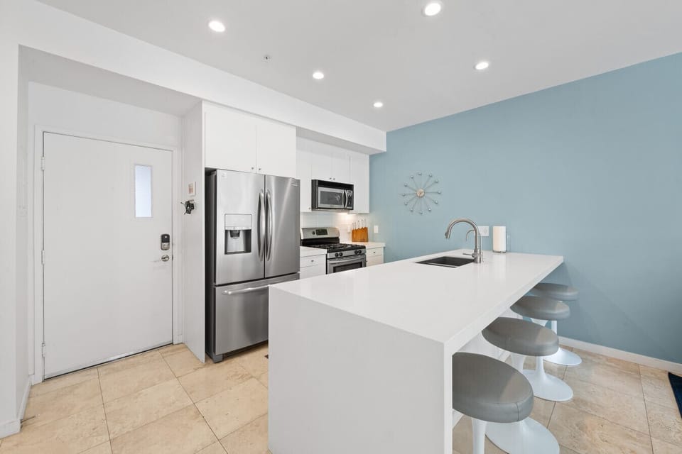 Clean and Spacious Kitchen with Sleek Countertops and Additional Seating