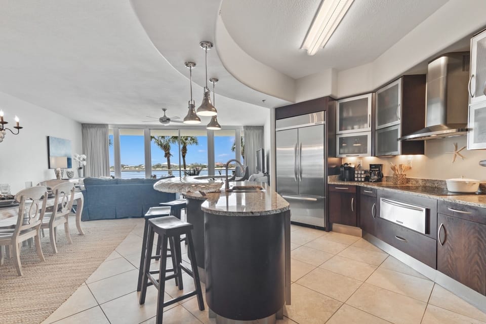 This gourmet kitchen, featuring stainless steel appliances and granite countertops, seamlessly flows into the spacious living area, perfect for entertaining and enjoying breathtaking views.