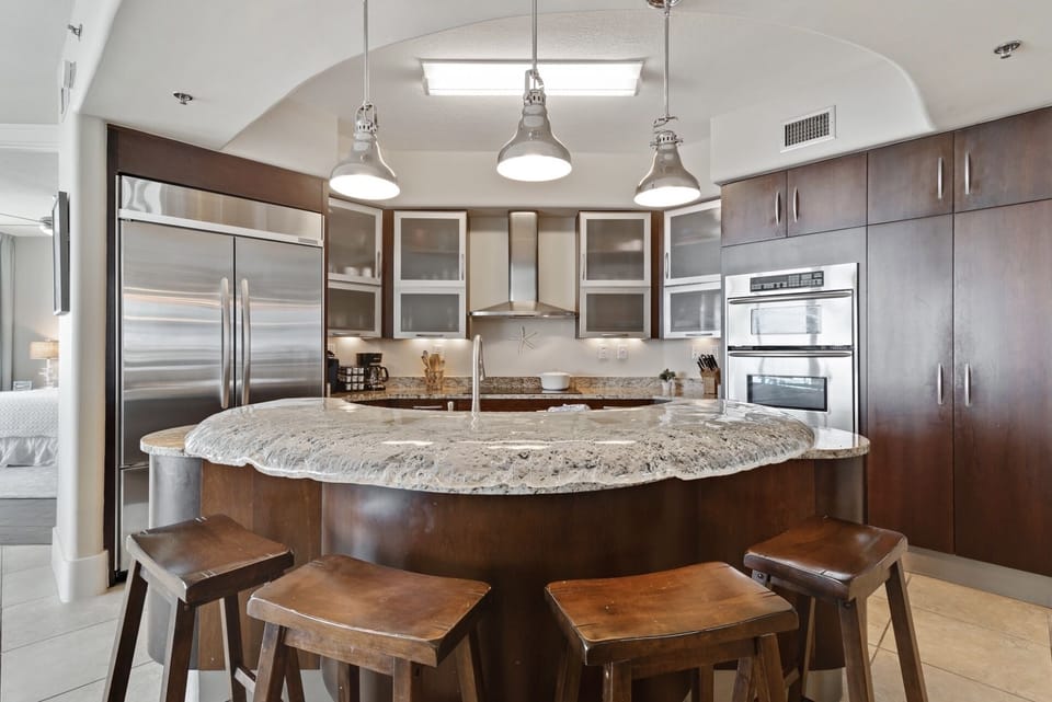 The modern kitchen island with bar seating offers a casual dining option, while the open layout maximizes natural light and showcases the stylish finishes throughout.