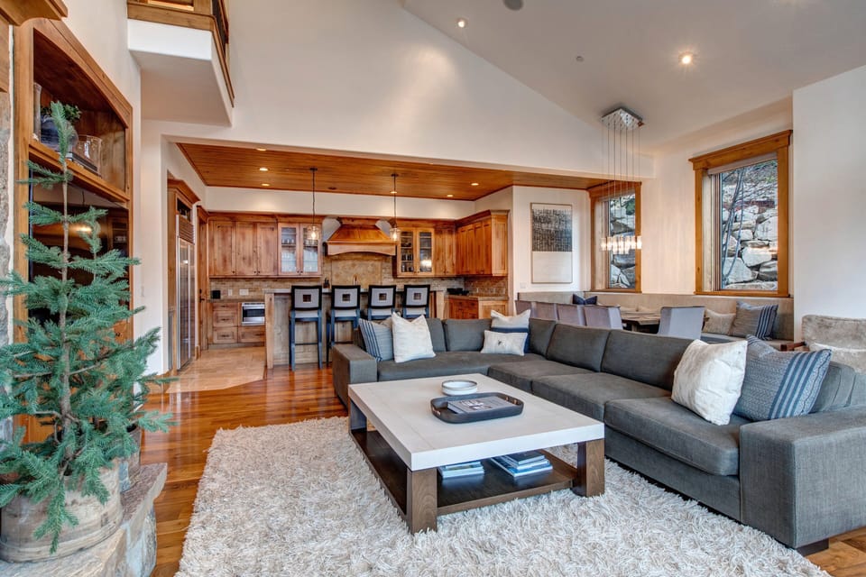 Living Room with plush sectional sofa, 65" Samsung smart tv, gas-assist fireplace, two separate seating areas, and private balcony access