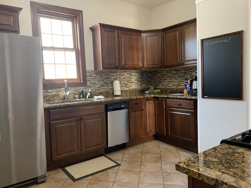 Side-by-side refrigerator with water and ice dispenser and dishwasher.