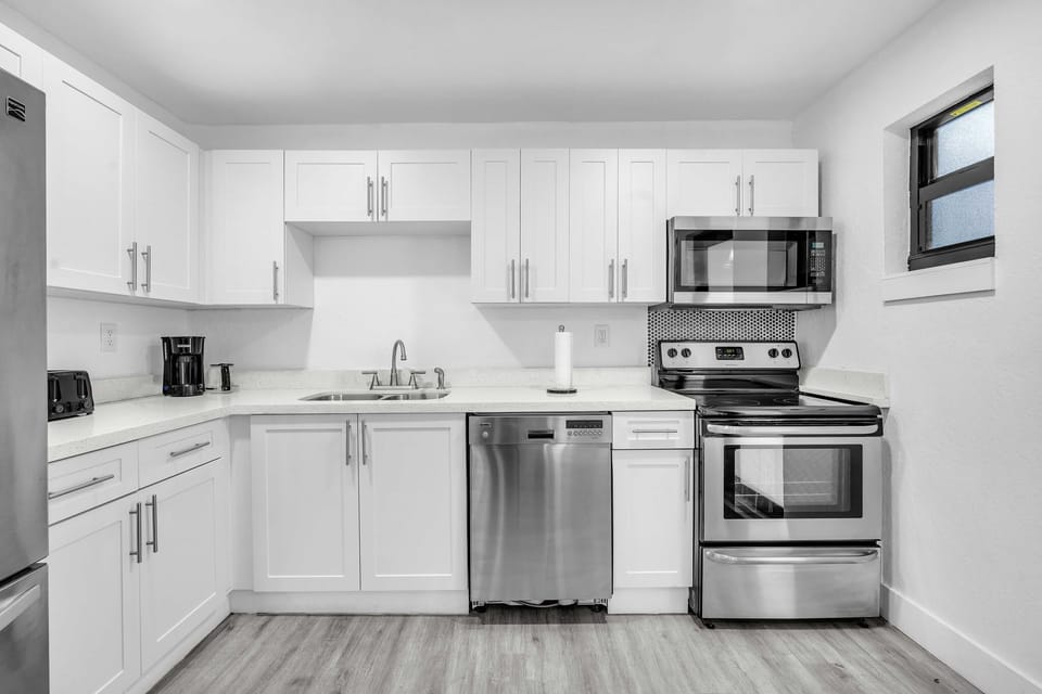 A sleek, clutter-free kitchen with all the necessary amenities, including a spacious refrigerator, dishwasher, and essential cooking tools.