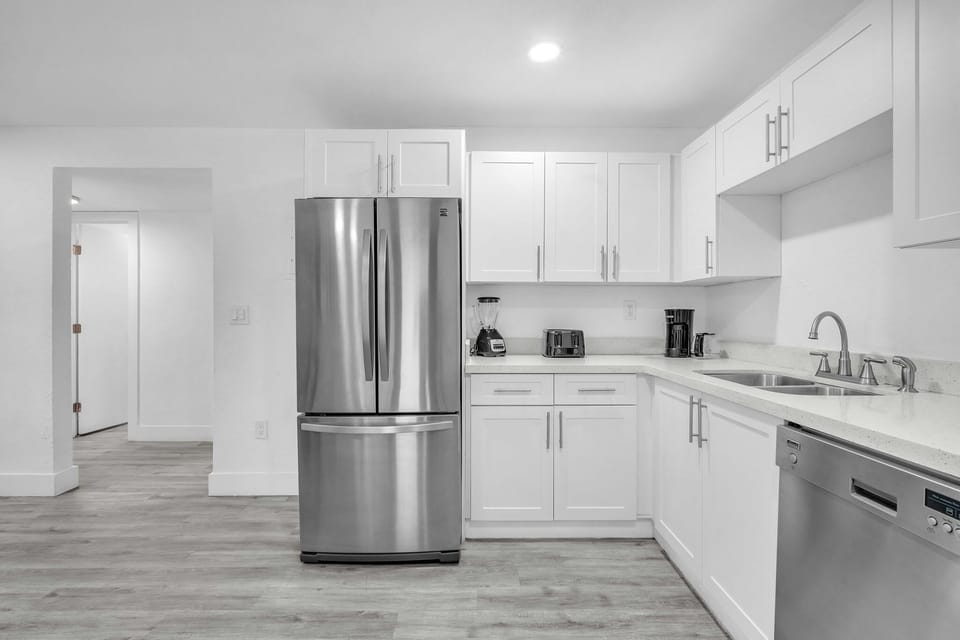 A sleek, clutter-free kitchen with all the necessary amenities, including a spacious refrigerator, dishwasher, and essential cooking tools.