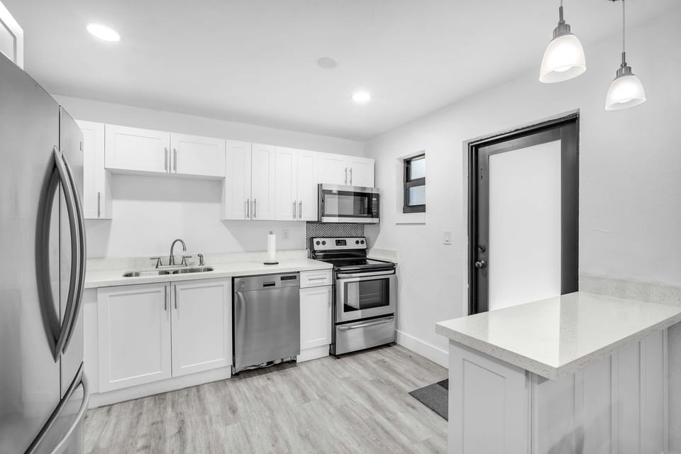 A sleek, clutter-free kitchen with all the necessary amenities, including a spacious refrigerator, dishwasher, and essential cooking tools.