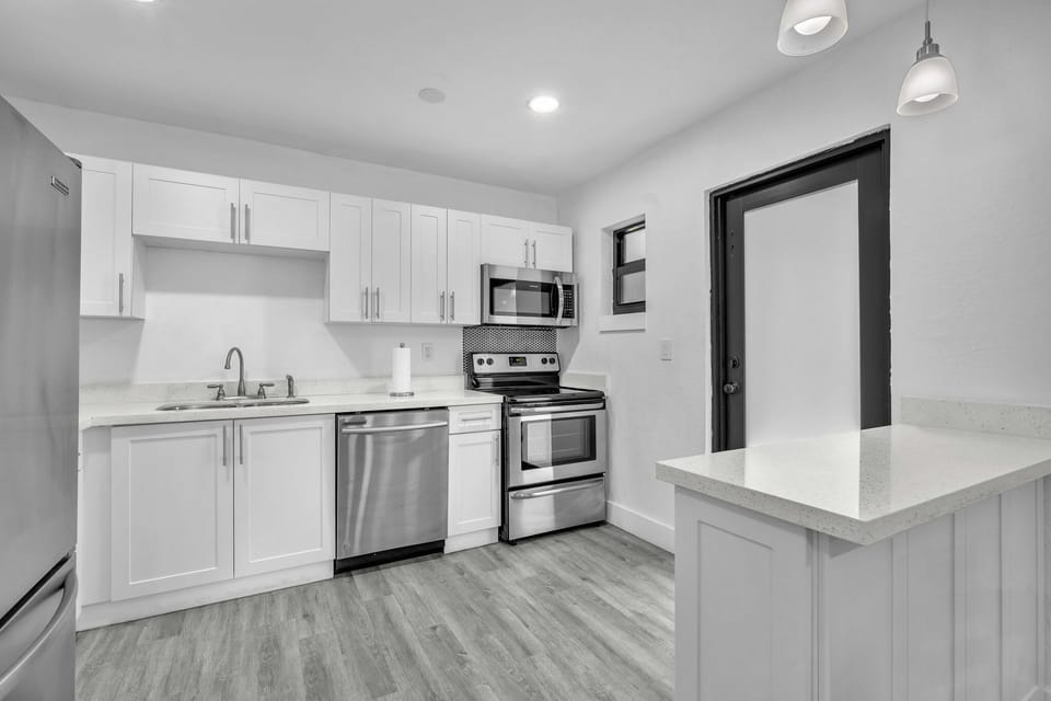 Ample kitchen space, thoughtfully furnished with stainless steel appliances, a sizable refrigerator, and all the essential kitchen necessities.