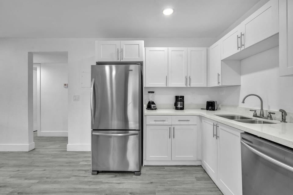 Ample kitchen space, thoughtfully furnished with stainless steel appliances, a sizable refrigerator, and all the essential kitchen necessities.