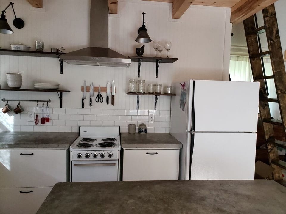 Fully remodeled and equipped kitchen for cooking needs. Open, upper shelving. 
