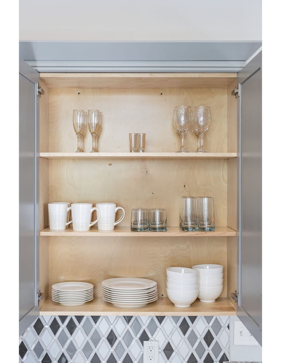 Galley-style, fully equipped kitchen with open flow to living/dining area. Fully stocked with essentials, from mixing bowls to wine glasses. Features stainless steel appliances, gas range, stone countertops, tile backsplash for a luxurious feel!