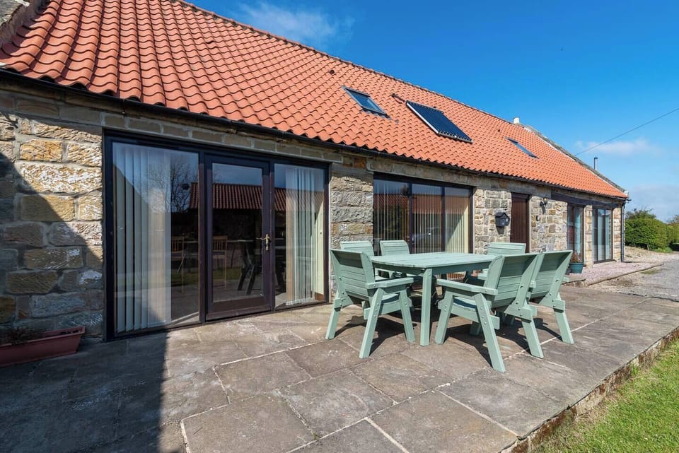 The holiday home features 3 bedrooms, 2 bathrooms, bed linen, towels, a flat-screen TV, a dining area, a fully equipped kitchen, and a patio with garden views.