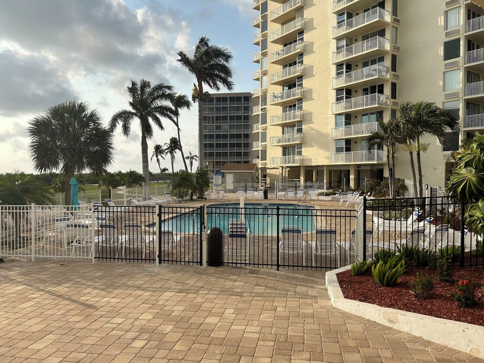 Heated community pool with chairs and umbrellas