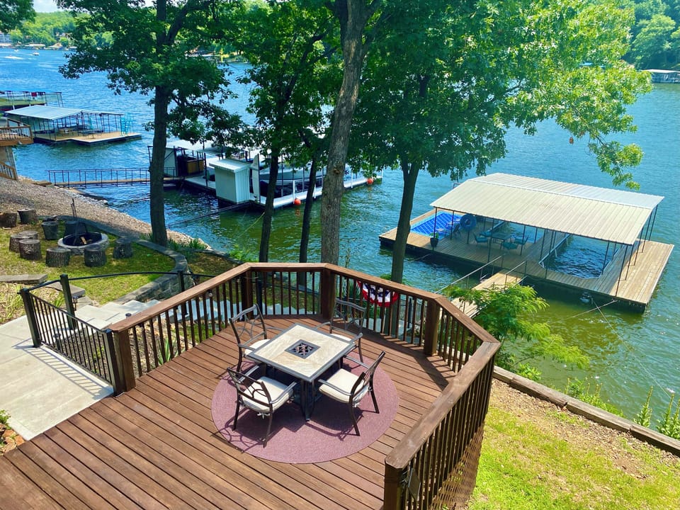 martini deck with beautiful cove views, concrete steps to dock, and a firepit