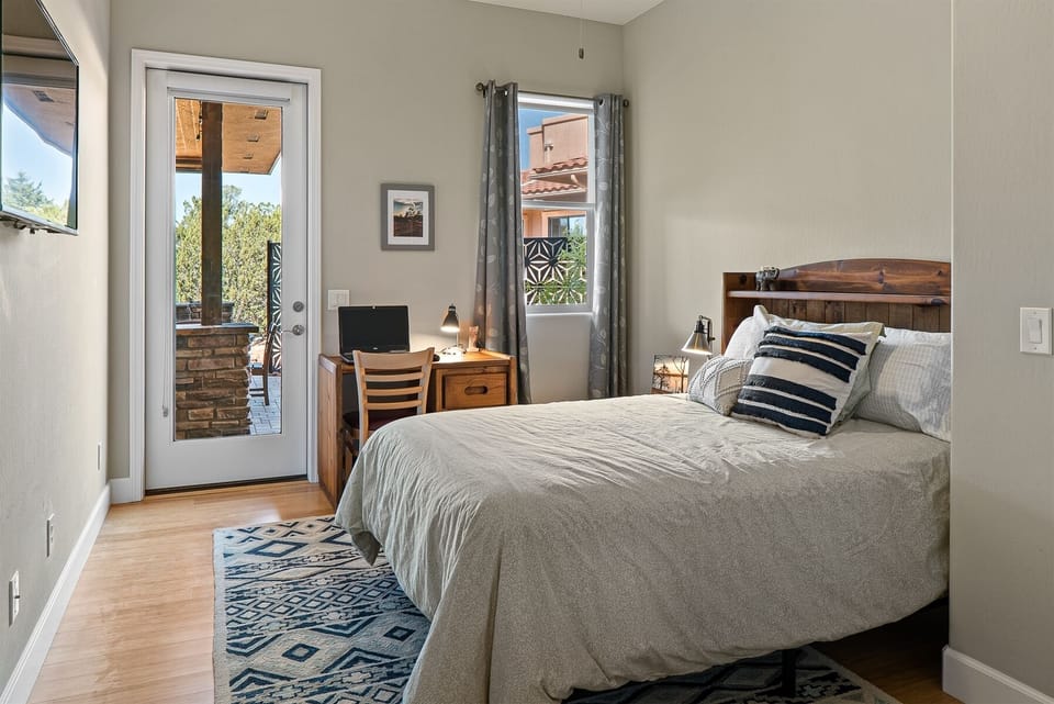 Bedroom 3 has a double bed with a workspace and access to the back patio
