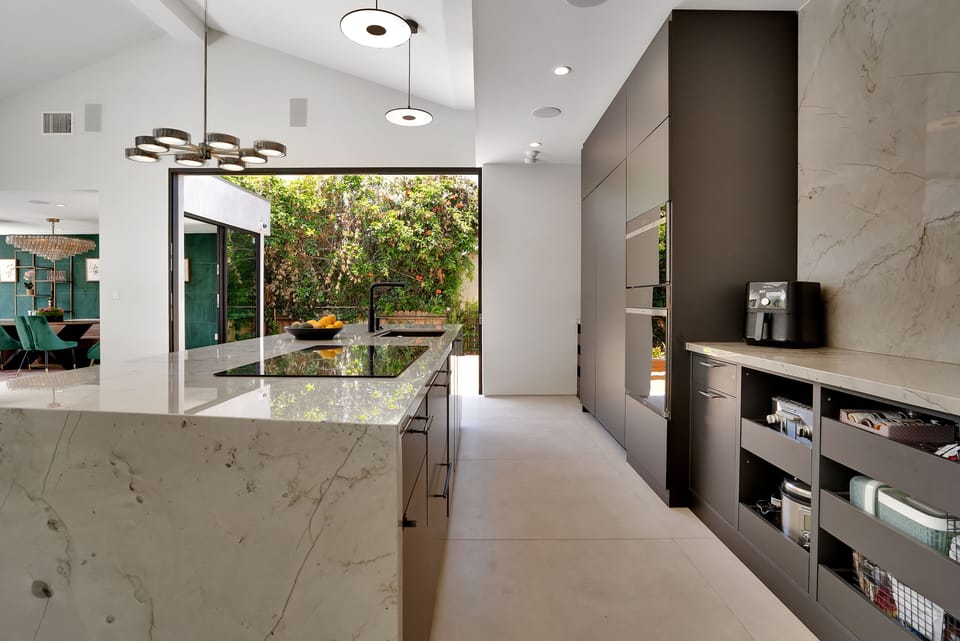 Fully stocked kitchen opening up to a a sunken deck with a gas firepit .