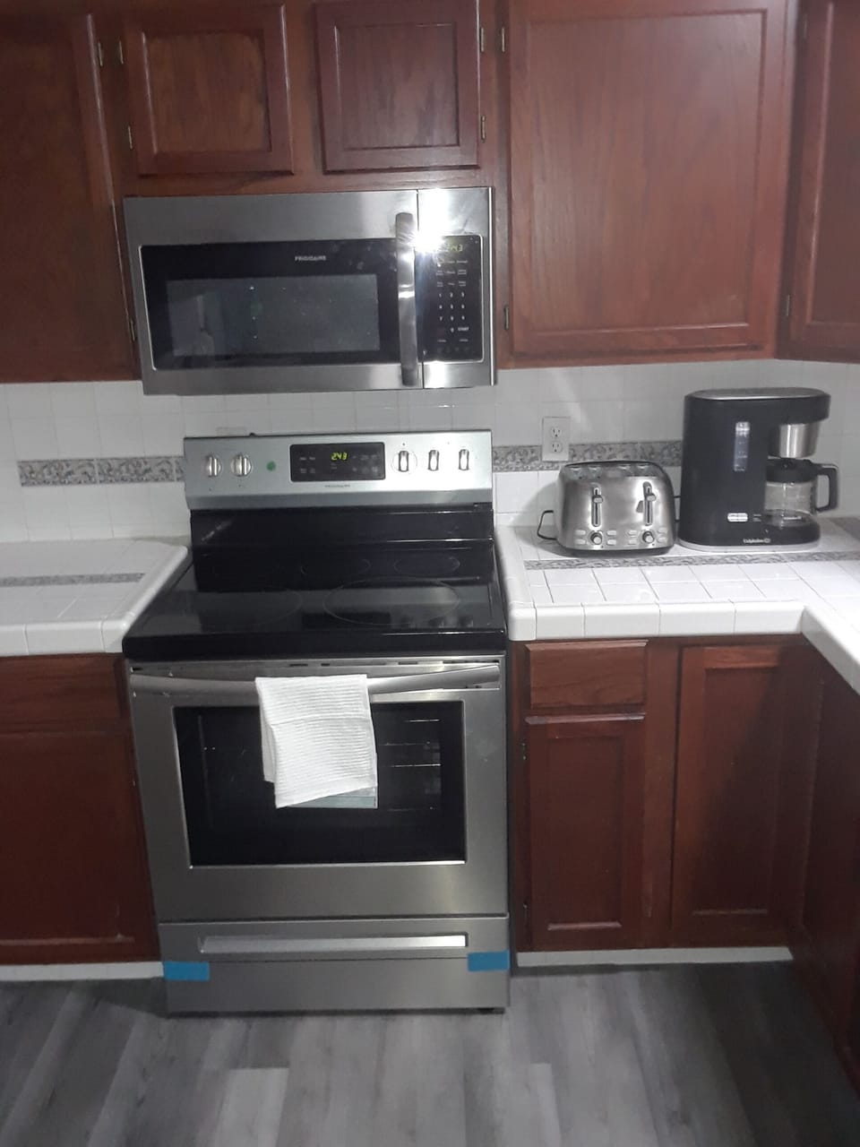 Stainless steel appliances range, overhead microwave, toaster, coffee maker.