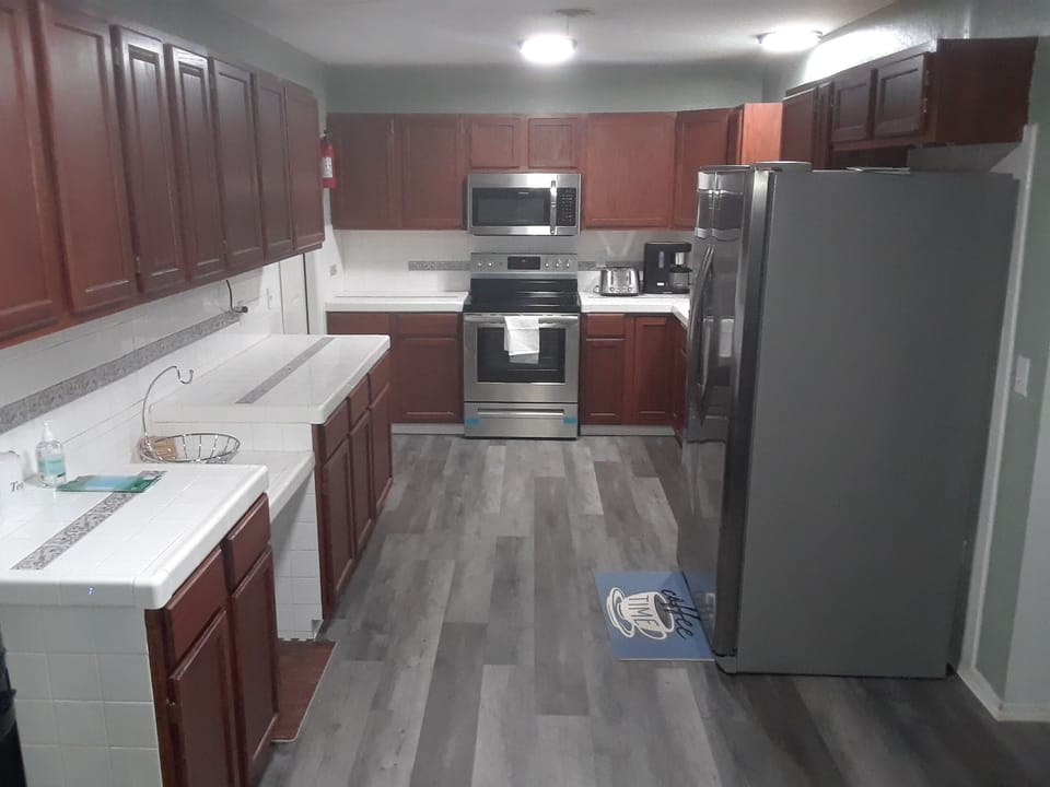 Large kitchen with tons of cabinets and all new stainless steel appliances.
