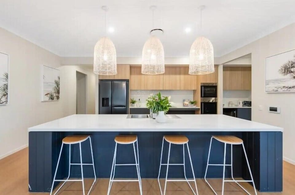 Open-plan kitchen with accessible sink, cooktop and coffee station.