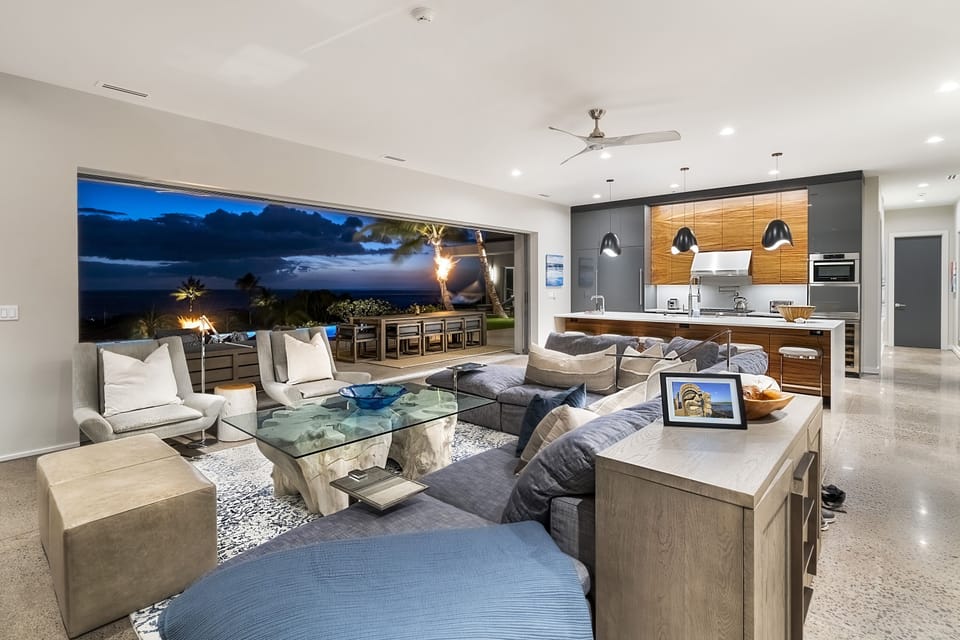 Game-players in the great room, laughing with family chefs in the professional kitchen as friends come in from the pool at sunset