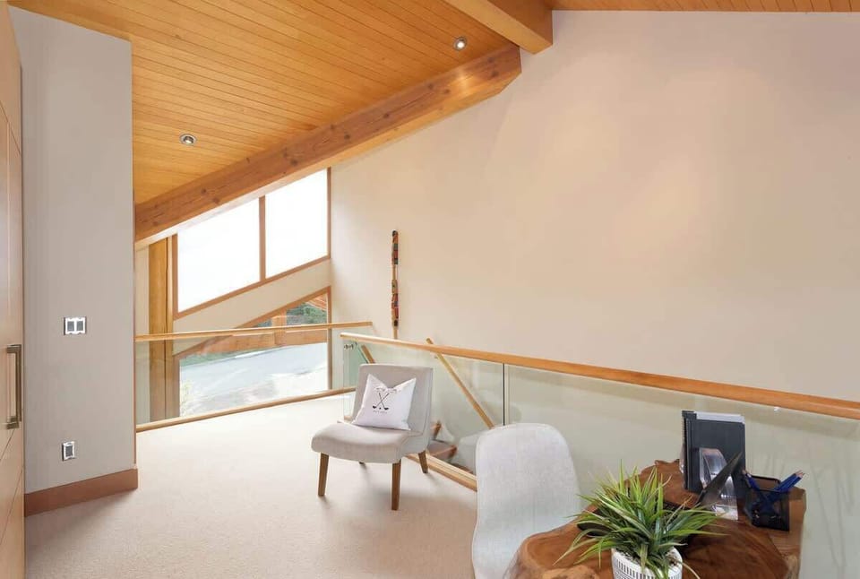 - Bright loft nook with cozy chairs and serene mountain light  
- A quiet corner to relax, read, or enjoy a morning coffee  
- Surrounded by warm wood textures and alpine charm  