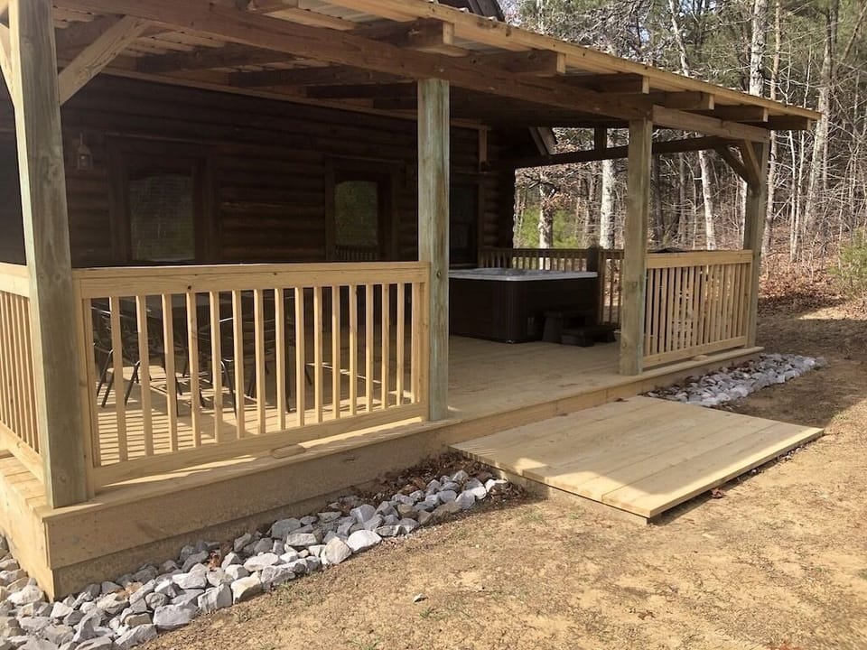 Large back deck with hot tub, grill and seating.