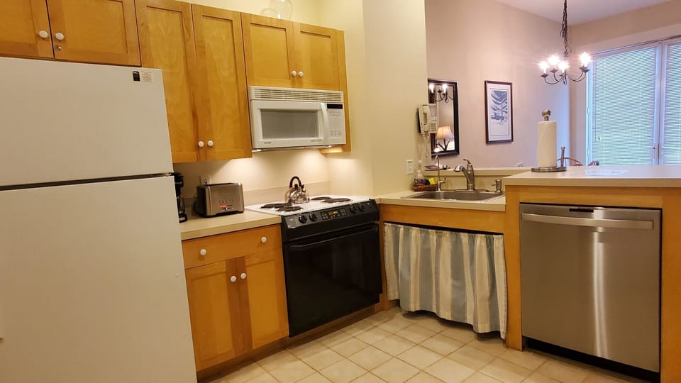 Open kitchen w/ microwave, toaster, coffee maker, china, utensils, & cookware.  