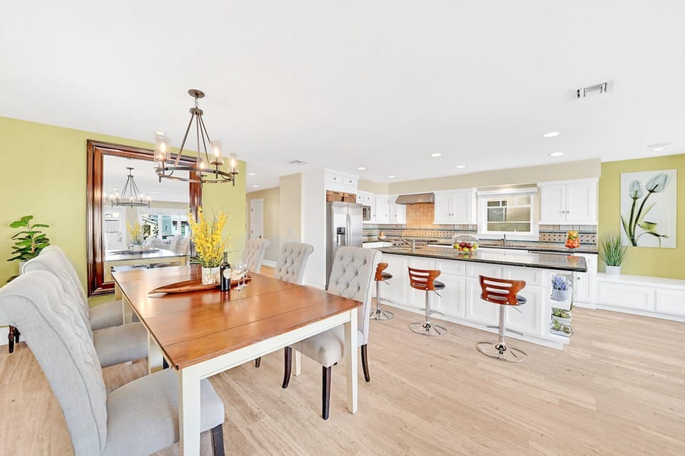 The dining area opens to the kitchen, with its bar stool seating, large island, and high-end appliances.
                