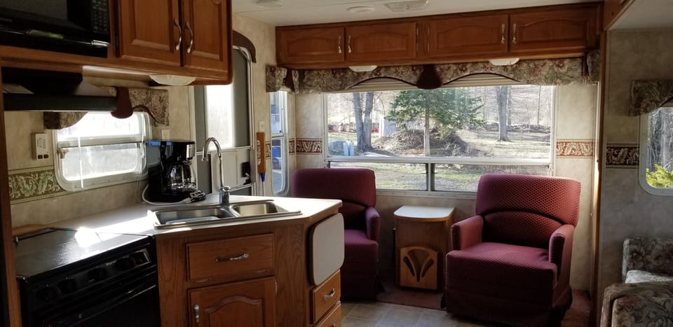 Living area w/ full kitchen, comfy seating, pull out sofa, and lots of windows