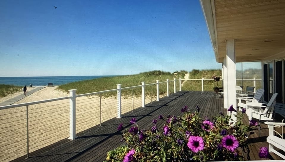 View of the beach and water from deck seating.