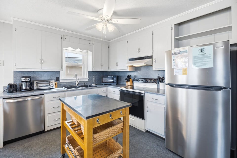 The fully stocked kitchen includes a full-sized refrigerator, microwave, icemaker, and dishwasher, making meal prep easy for families.