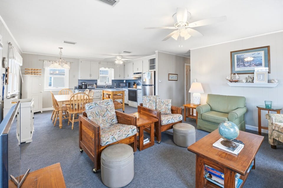 The main living area combines a comfortable seating arrangement with a TV, perfect for relaxing after a day at the beach.
