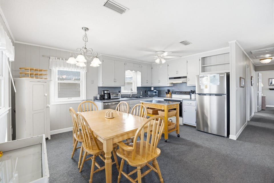 The fully stocked kitchen includes a full-sized refrigerator, microwave, icemaker, and dishwasher, making meal prep easy for families.