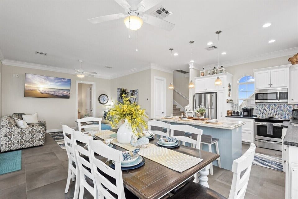 Spacious dining and kitchen area with coastal décor and open layout for gatherings.