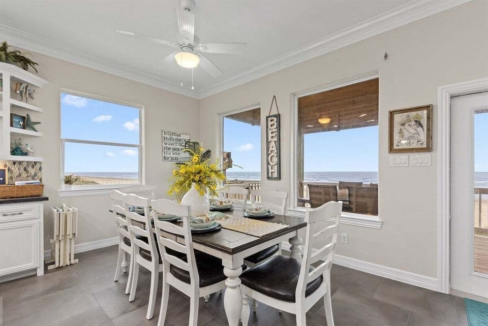 Dining space with beach views and direct access to outdoor balcony.