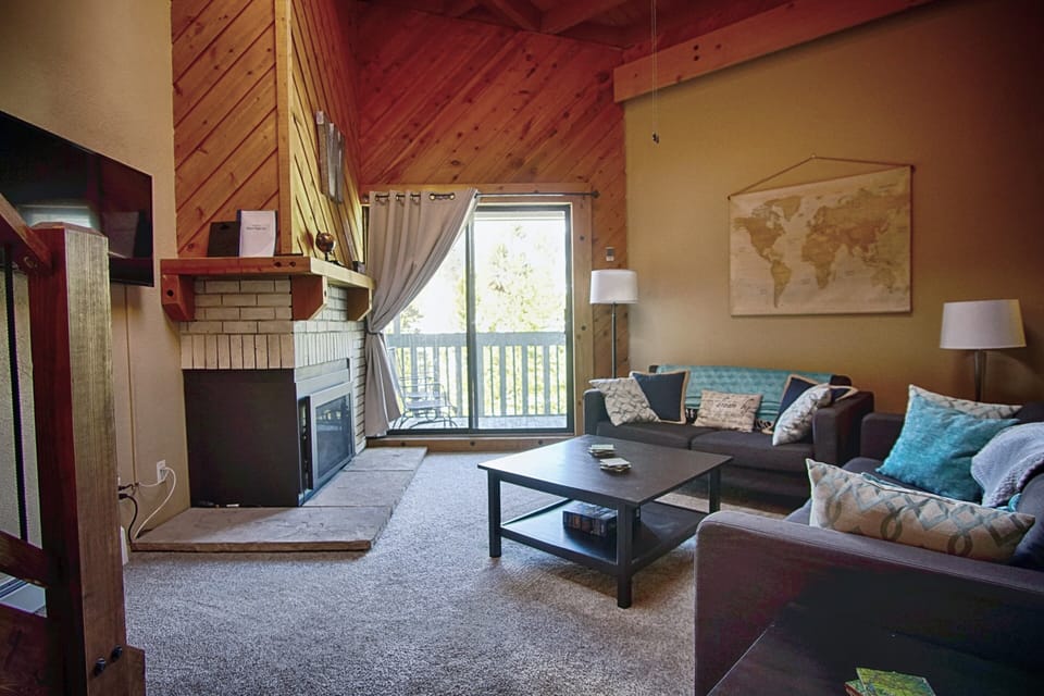 Living room with doors to balcony, gas fireplace and smart TV