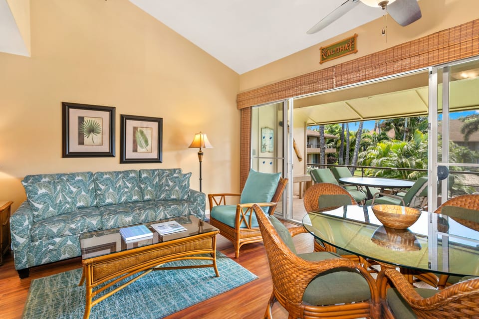 Your island-style living room opens to a palm-framed balcony where warm ocean breezes and tropical greenery create your perfect Hawaiian escape.