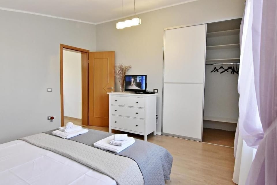 The bedroom with the wardrobe, the chest of drawers with the flat-screen satellite TV.