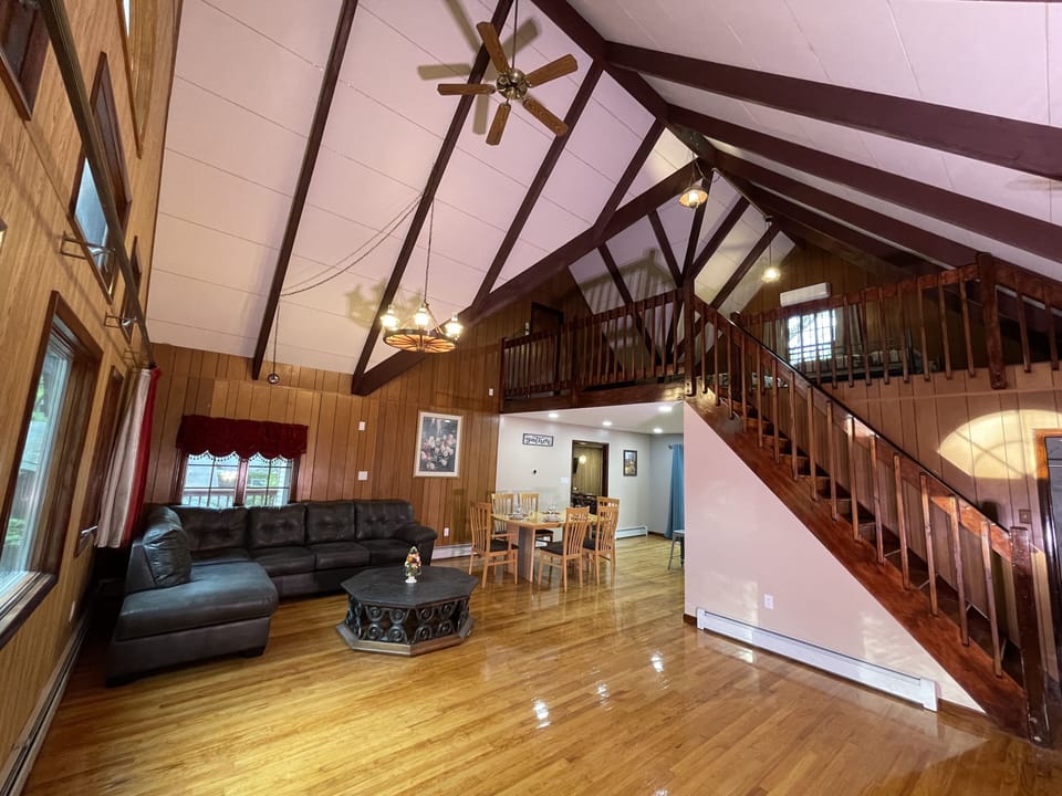Large living room with tall cathedral ceiling with view of 3rd floor loft.