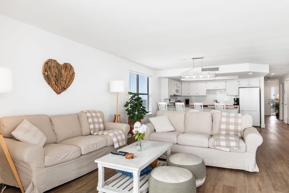 Sink into plush sofas in your bright, open living space where coastal charm meets modern comfort for perfect relaxation.