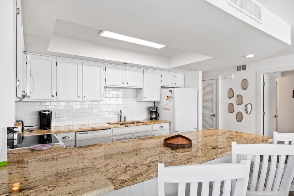 Cook and gather around this spacious granite island kitchen with modern appliances and bright white cabinetry for your culinary adventures.