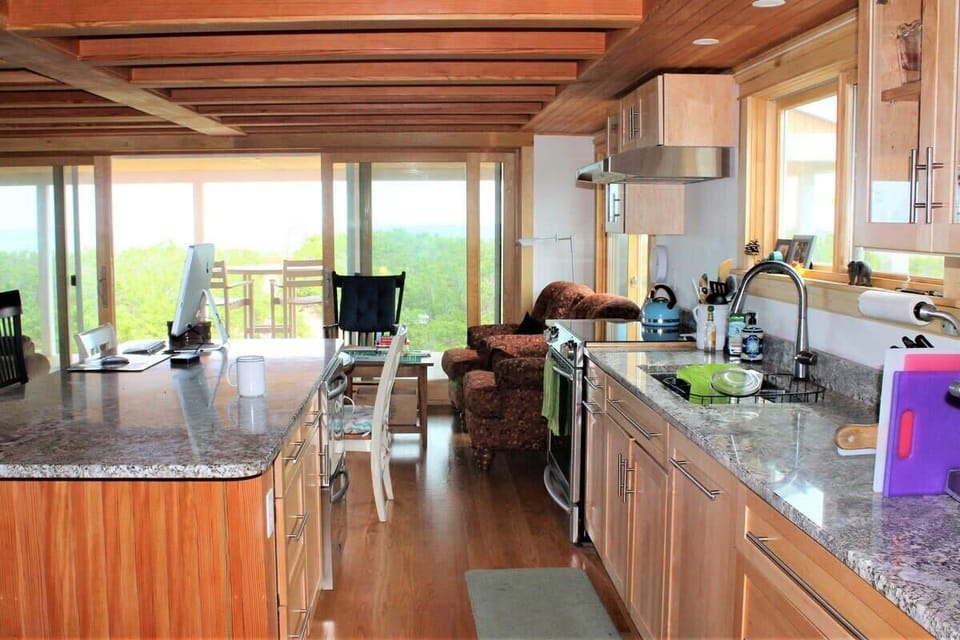 Open concept kitchen and living room with large windows to enjoy plenty of natural light.