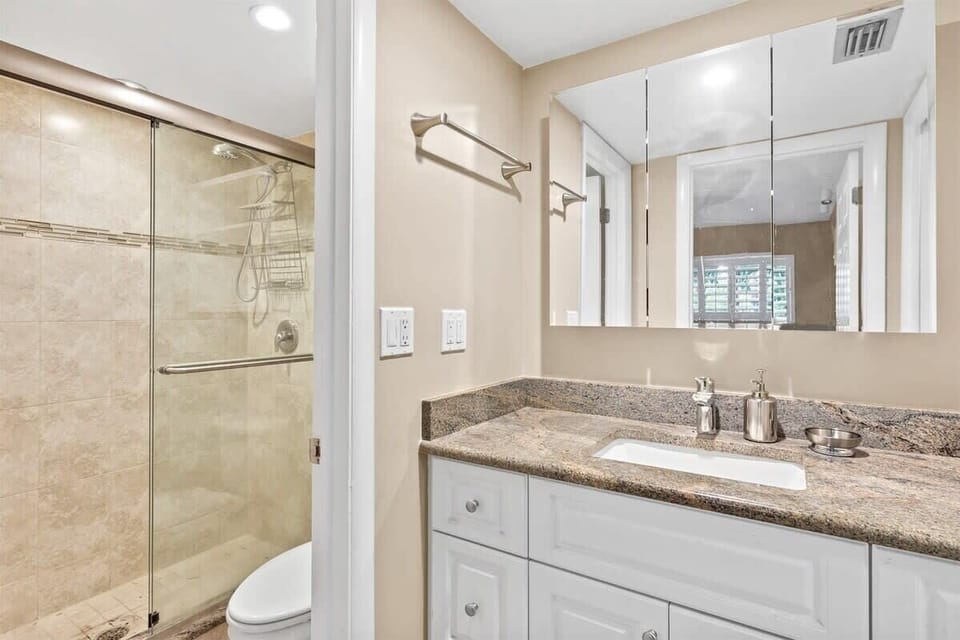 Full bathroom, located in hallway between master bedroom and living room, featuring walk in shower. 
