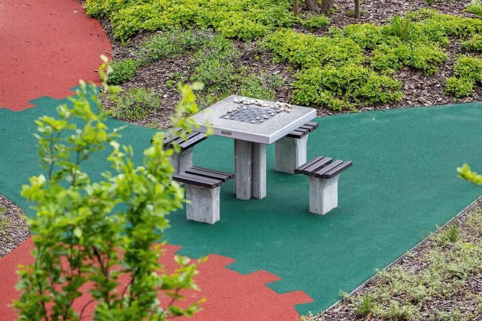 A scenic balcony view overlooking a vibrant children’s playground and greenery.