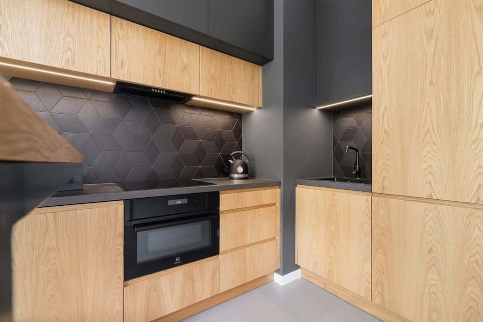 A detailed look at the sleek kitchen with wood finishes, black accents, and a compact design perfect for functionality.