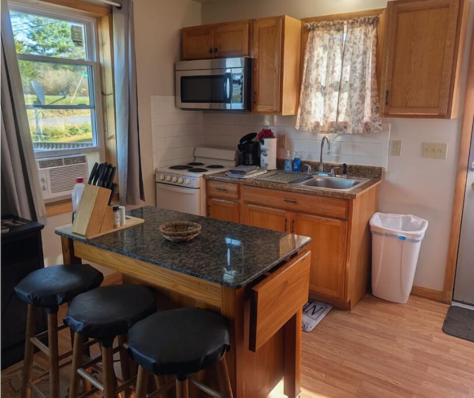 Kitchen has mobile island for extra cooking space or as dinette for meals.