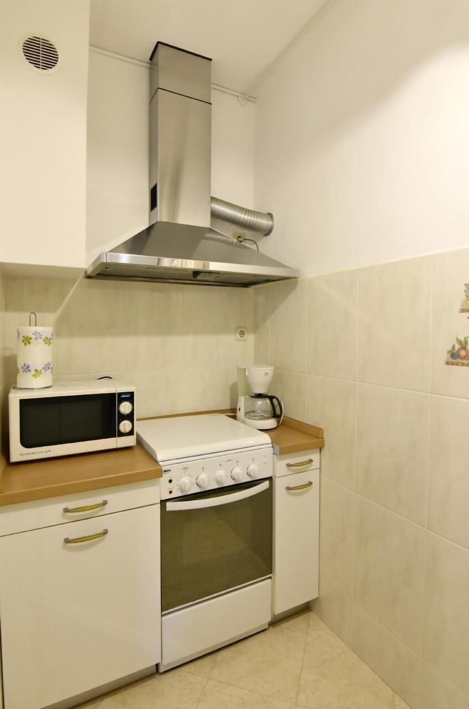 The kitchen equipped with microwave oven, smoke extractor hood, coffee machine