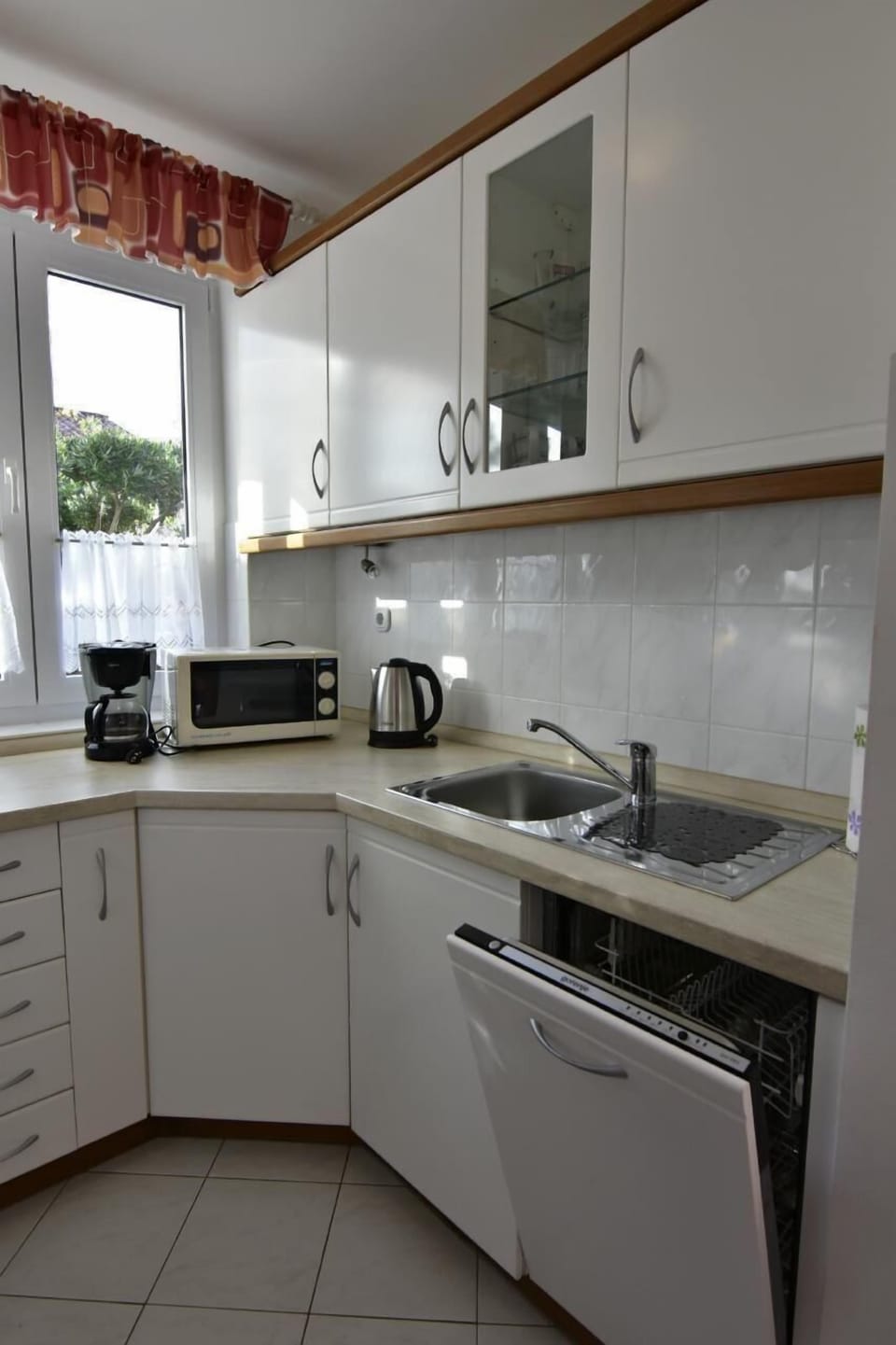 The kitchen is equipped with a dishwasher, microwave oven, kettle, coffee machine