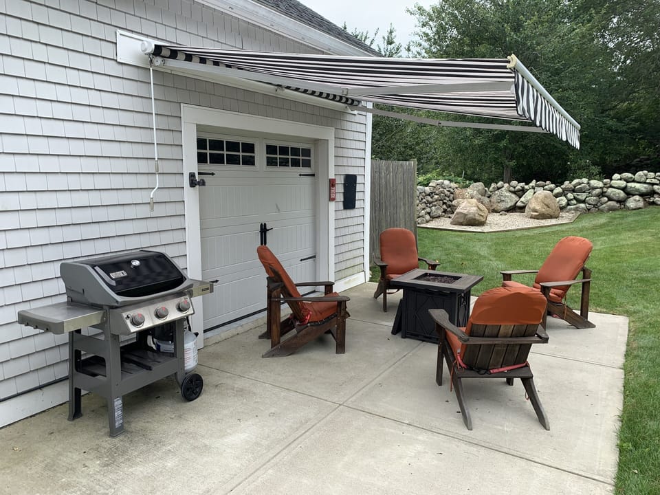 Grilling area w/propane fire pit for damp days and an awning for the sunny ones