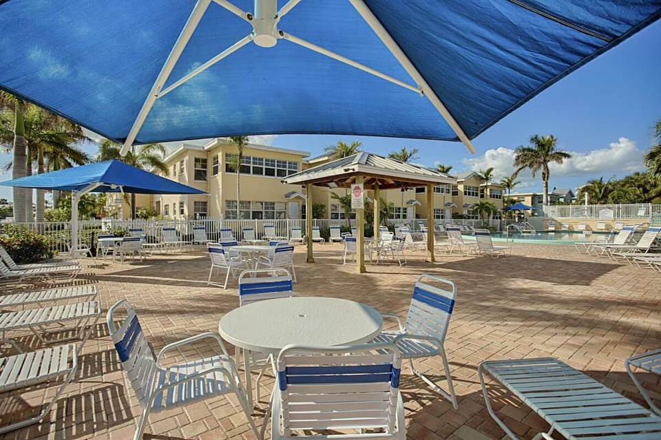 Sip something cool under shade while pool life unfolds.